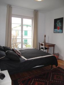 a bedroom with a bed and a large window at IBERIA 1 appartement T3 à 200 m de la plage avec parking privé in Hendaye