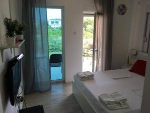 - une chambre avec un lit blanc et un balcon dans l'établissement Apartment Trebinje, à Trebinje