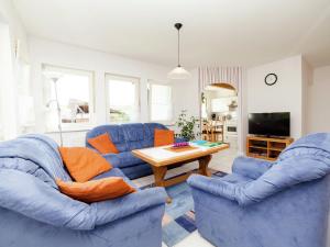 a living room with two blue couches and a table at Apartment in Densberg with terrace in Densberg