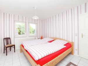 a bedroom with a large bed and a chair at Apartment in Densberg with terrace in Densberg