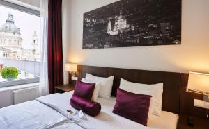 a hotel room with a bed with purple pillows at 12 Revay Hotel in Budapest
