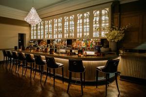a bar with a row of chairs in a room at The County Hotel Newcastle in Newcastle upon Tyne