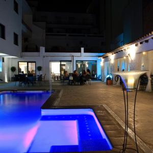 a swimming pool in a building at night at Hotel Salomé in Calafell