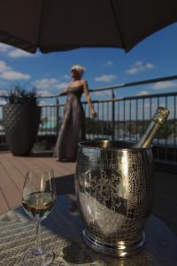 una botella de vino en un cubo sobre una mesa con una copa en Hotel Dux, en Roermond