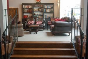 una sala de estar con sofás y sillas y una escalera en The Dragon Hotel en Montgomery