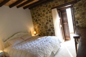 - une chambre avec un lit et un mur en pierre dans l'établissement Spiti tis Irinis, à Pedoulas