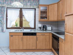 a kitchen with wooden cabinets and a sink and a window at Lovely Mansion in Lirstal with Terrace in Lirstal