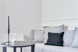 a white couch with pillows and a table with a lamp at Elite Apartments Marine Mila Baltica in Gdańsk