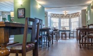 a dining room with tables and chairs in a restaurant at The Dragon Hotel in Montgomery