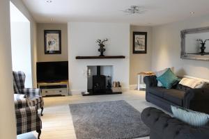 a living room with a couch and a tv at The Manor House in Fenwick