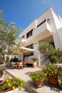 a house with a patio with tables and chairs at Hotel Piccolo Mondo in San Vito lo Capo