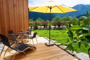 een patio met een tafel en een gele parasol bij Ferienwohnung Almflair Chalet in Thiersee