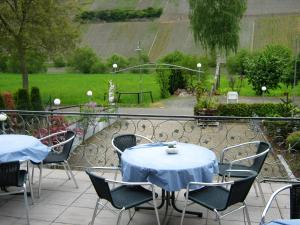 a patio with tables and chairs and a view of a garden at Gästehaus Schneider in Brauneberg