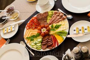 a plate of food with meat and vegetables on a table at BH Kristály in Debrecen