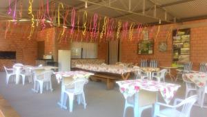 a dining room with tables and chairs and colorful tables and chairs at Pousada Longe Vista in Tibagi