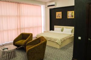 1 dormitorio con 1 cama y 2 sillas en Paradise Hotel, en Saryaghash