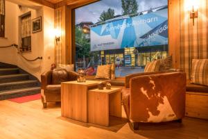 a room with two chairs and a table and a window at Hotel Cheminee in Zermatt