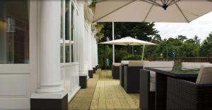 
a patio area with chairs and umbrellas at The Falcon Hotel in Farnborough
