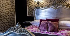 法恩伯勒The Falcon Hotel的一张带金属床头板的床和两个枕头