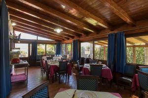 a dining room with tables and chairs and windows at Villa Margherita in Pozzallo
