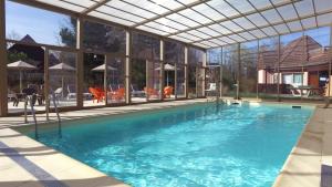 a large swimming pool with a large building with windows at VVF Plaine d'Alsace Obernai Strasbourg in Obernai