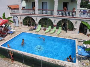 an overhead view of a swimming pool with people in it at Apartments & Rooms Lo & Mar in Medulin