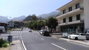an empty street with cars parked on the side of a building at Ape Esquerdo in São Vicente