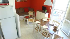 cocina y sala de estar con mesa y nevera en VVF Drôme Provence, en Montbrun-les-Bains