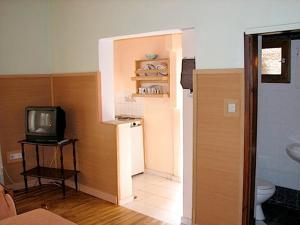 Habitación con baño, TV y nevera. en Earini Rooms And Apartments en La Canea