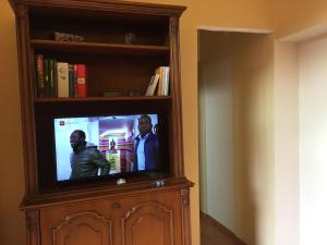 Ein Fernseher in einem Bücherregal mit zwei Männern drauf. in der Unterkunft Palazzo di Città in Saluzzo