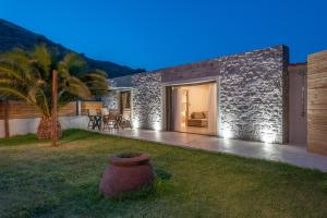 a house with a stone wall and a patio at ARMONIA 1 & 2 in Myrina