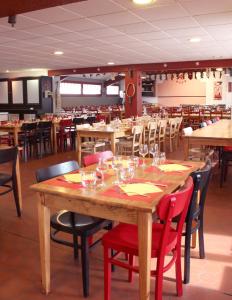 uma sala de jantar com mesas e cadeiras de madeira em VVF Pays Basque Sare La Rhune em Sare