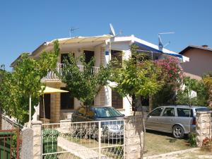 uma casa com dois carros estacionados em frente em Apartments Solomon em Privlaka