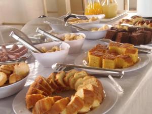 a table filled with different types of pastries and desserts at Hotel Miranelli in Barbacena