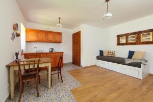 a kitchen and a living room with a bed and a table at Arácsi Vendégház in Balatonfüred