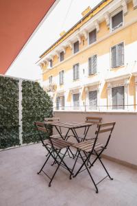 stół i krzesła na patio przed budynkiem w obiekcie Vatican Relais Rome Suite w Rzymie
