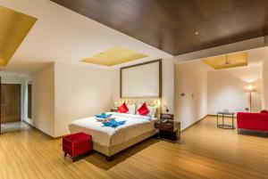 乌贾因Hotel Abika Elite的卧室里有一张大床，配有红色枕头 更多35张照片
