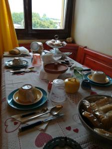 a table with plates and utensils on it at Casa Maia in Padova