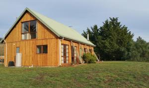 drewniana stodoła z zielonym dachem na polu w obiekcie Charles Reuben Estate w mieście Hobart