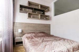 ブダペストにあるApartment at Nagymezőのベッドルーム1室(ベッド1台、壁に棚付)