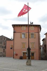 a flag on a pole in front of a building at Apartments Boscarin in Buje
