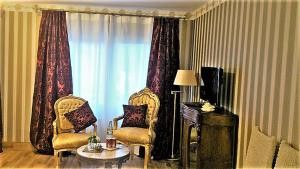 a living room with two chairs and a table and a window at Héritage B&B in Mülheim an der Mosel