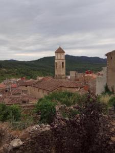 un pueblo con una torre de reloj en una colina en Cal Estevet, en Arboli