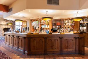 - un bar avec un grand comptoir en bois dans une pièce dans l'établissement Meadow Farm Redditch by Marstons Inns, à Redditch