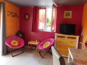 Mirabel-aux-Baronniesにあるvilla les Pinsのリビングルーム(ピンクの椅子、テレビ付)