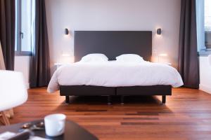 une chambre avec un grand lit avec des draps blancs dans l'établissement LOFT luxe hyper centre: terrasse/piscine/ salle de sport, à Bordeaux 19 autres photos
