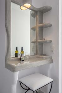 a bathroom with a sink with a mirror and a stool at Villa Sosanna in Pollonia