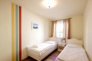 una camera con due letti e una finestra di Apartmenthaus Hus Übi by Rujana a Binz