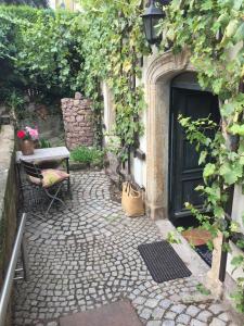 eine Terrasse mit einem Tisch, einer Bank und einer Tür in der Unterkunft Ferienwohnung am Weinberg in Meißen