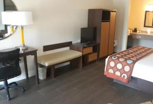 a hotel room with a bed and a desk and a television at Super 8 by Wyndham Florida City/Homestead/Everglades in Florida City